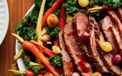 Tranches de magret de canard juteux, accompagnées de carottes rôties, d'oignons grelots et de chou frisé. Un plat savoureux et coloré.