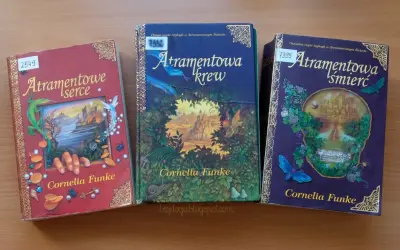 Trzy książki z serii "Atramentowy Świat" Cornelii Funke: "Atramentowe serce", "Atramentowa krew" i "Atramentowa śmierć".