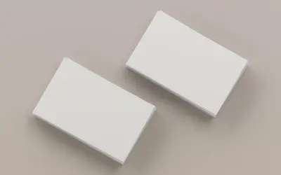 Dwie stosy białych wizytówek na neutralnym tle. Idealne do nauki, jak wydrukować wizytówki.