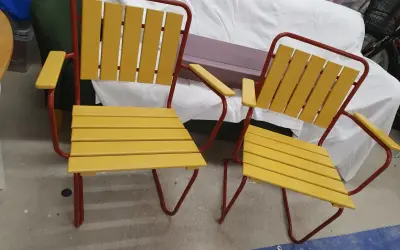 Två gula och röda **grythyttan stolar gamla modeller** står bredvid varandra.