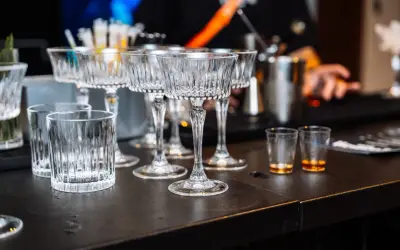 Eleganckie kieliszki i szklanki czekają na gości weselnych przy samoobsługowym drink barze. Idealne miejsce na drinki z przepisami.