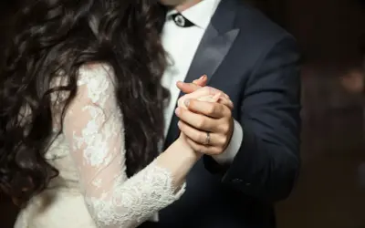 Para młoda tańczy, trzymając się za ręce. Jej długa, ciemna fryzura opada na koronkową suknię. On w eleganckim garniturze. To śpiewa dobry moment.