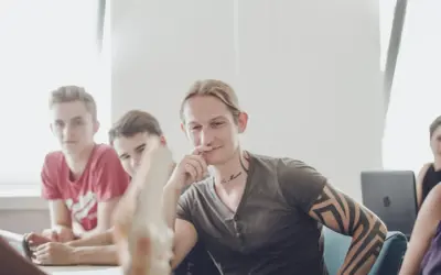 Junge Männer im Gespräch, einer mit Tattoos, vielleicht beim bachelor physiotherapie berufsbegleitend.