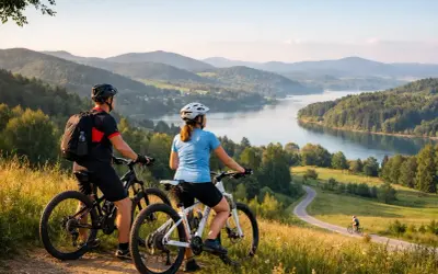 Para rowerzystów podziwia malowniczy krajobraz z jeziorem i wzgórzami. Idealne miejsce na odkrywanie tras rowerowych Podkarpacia.