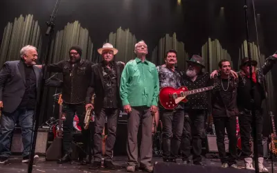 Zespół muzyczny na scenie, w tym Bill Murray w zielonej koszuli, gotowy na koncerty.