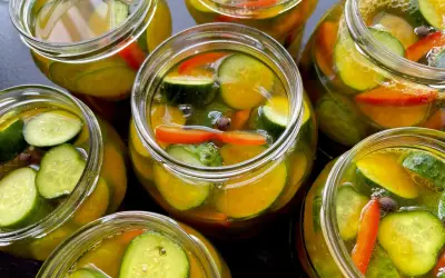 Słoiki pełne chrupiących ogórków z papryką i przyprawami, gotowe na zimę. Te ogórki w curry zachwycą smakiem!