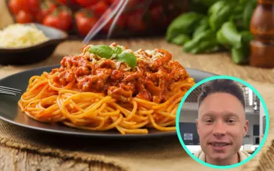 Pyszne spaghetti bolognese na talerzu, a obok uśmiechnięty mężczyzna. Zastanawiasz się, ile kcal ma spaghetti bolognese?