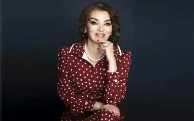 Uśmiechnięta kobieta w sukience w białe kropki, niczym z lat 50. Jej styl to klasyczna polka.