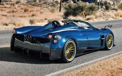 Niebieski Pagani Huayra Roadster na pustynnej drodze. Jego cena jest astronomiczna, ale widok zapiera dech w piersiach.