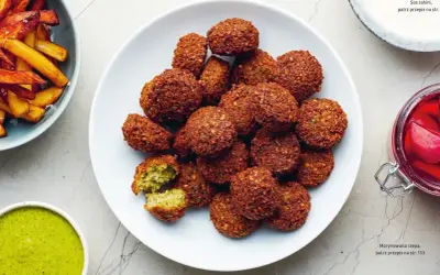 Talerz pełen chrupiących kuleczek falafel, które zachęcają do spróbowania. To pyszne danie, które warto poznać!
