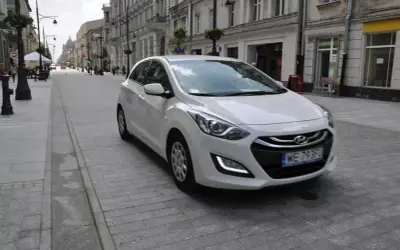 Biały Hyundai i30 1.4 benzyna na brukowanej ulicy w mieście.