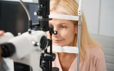 Kobieta poddawana badaniu pachymetrii oka. Urządzenie mierzy grubość rogówki, kluczowe dla diagnostyki jaskry.