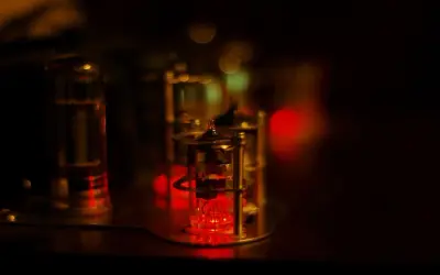 Czerwone żarzące się lampy elektronowe, jak w starym sprzęcie audio. W tle rozmyte światła, tworzące magiczny nastrój.