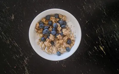 Un bol de skyr avec des myrtilles, des rondelles de banane et du granola. On peut chauffer le skyr pour un petit-déjeuner réconfortant.