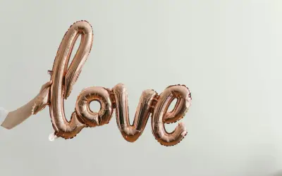 Różowe balony w kształcie napisu "Love" unoszą się w powietrzu. To symbol bezwarunkowej miłości matki do dziecka, jak w pięknych cytatach.