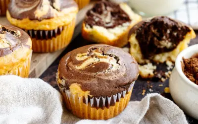 Marmorierte Muffins, perfekt für ein schnelles Muffins Rezept. Ein Muffin ist angeschnitten und zeigt den saftigen Teig.