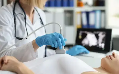 Lekarka wykonuje badanie USG piersi, analizując obraz na monitorze pod kątem oceny birads.