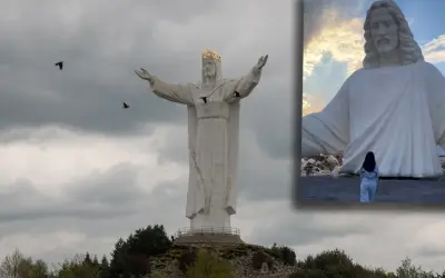 Największy pomnik Jezusa na świecie, z koroną na głowie i rozłożonymi ramionami, majestatycznie góruje nad krajobrazem.