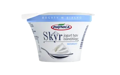 Opakowanie jogurtu typu islandzkiego Skyr Piątnica Naturalny z łyżką pełną jogurtu.