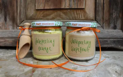 Zwei Gläser mit selbstgemachtem Saunasalz (Orange & Grapefruit) und eine Holzschaufel, verziert mit orangefarbenen Bändern.