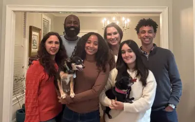 La familia anfitriona posa sonriente con sus dos perros.