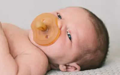 Neugeborenes Baby mit Schnuller. Die Frage "ab wann Schnuller?" beschäftigt viele Eltern.