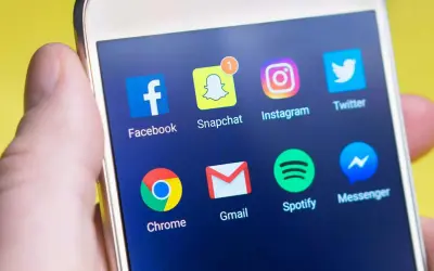 Ekran smartfona z ikonami aplikacji: Facebook, Snapchat, Instagram, Twitter, Chrome, Gmail, Spotify, Messenger. Dowiedz się, jak wyłączyć dostępność na Messengerze.