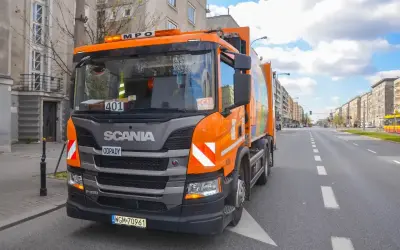 Pomarańczowy śmieciarka Scania na ulicy w Warszawie. Zakaz wjazdu tirów w centrum miasta nie dotyczy pojazdów komunalnych.