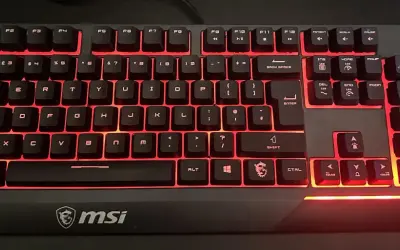 Klawiatura MSI z podświetleniem fn na klawiaturze. Czerwone światło emanuje spod klawiszy, tworząc futurystyczny wygląd.