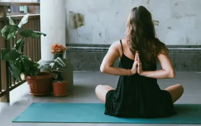 Donna in posizione yoga, mani giunte dietro la schiena, per alleviare i **secondo chakra bloccato sintomi**.
