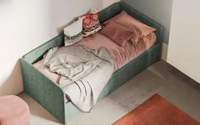 Divano fai da te con letto singolo, verde, con cuscini decorativi e coperta morbida.