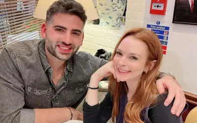Bader Shammas y Lindsay Lohan sonríen a la cámara, compartiendo un momento íntimo.