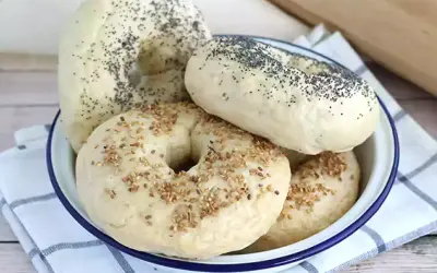 Färska bagels med vallmofrön och sesamfrön i en skål, redo för ditt bagels recept.