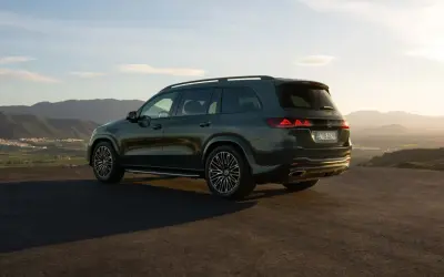 Mercedes más potente, un SUV oscuro aparcado en una colina con vistas a un valle al atardecer.