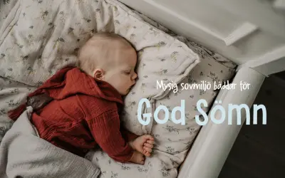 Sött barn sover i spjälsäng, inbäddat i mjukt tyg med blommor. En mysig sovplats som bäddar för god sömn.