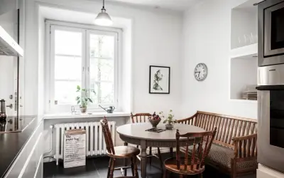Mysig köksvrå med runt matbord, träbänk och stolar. Perfekt för runt matbord inspiration.