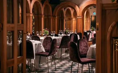 Elegant bank hotel lunch setting with plush chairs and arched wooden decor.