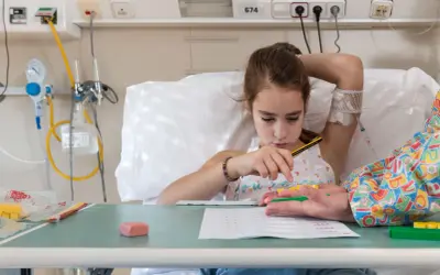 Niña en cama de hospital, con vía intravenosa, jugando con bloques. Un intento de combatir el síndrome de hospitalismo.