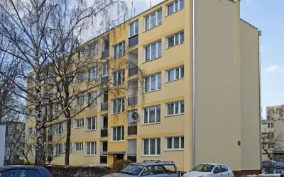 Żółty blok mieszkalny, zimowy dzień. Warto wiedzieć, jak zdać mieszkanie komunalne po śmierci najemcy.