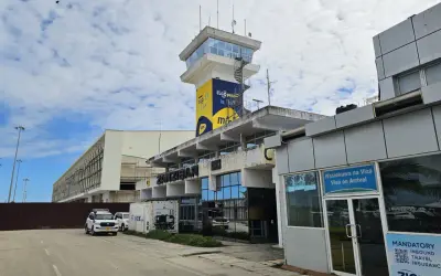 Kontrolltorn och terminalbyggnad vid Zanzibar flygplats. En vit SUV parkerad framför.