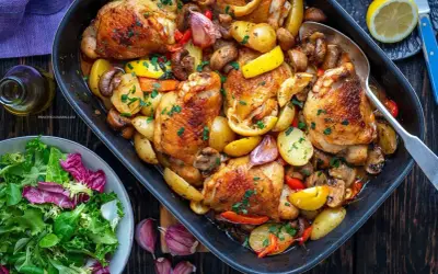 Pyszna ćwiartka z kurczaka pieczona z ziemniakami, pieczarkami i cytryną. Danie posypane świeżą natką pietruszki.