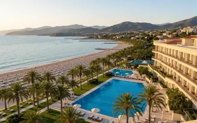 Luksusowy hotel z atrakcjami dla dorosłych, z basenami i prywatną plażą, otoczony palmami, z widokiem na morze i góry.