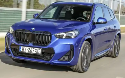 Niebieskie BMW X1 w ruchu. Zwróć uwagę na jego dynamiczne linie i kompaktowe bmw x1 wymiary, idealne do miasta.