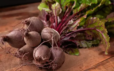Un bouquet de betteraves fraîches, prêtes pour une délicieuse recette betterave. Leurs feuilles vertes et leurs racines pourpres promettent saveur et couleur.