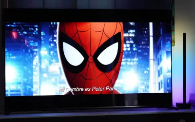 Spider-Man na ekranie telewizora, porównanie technologii QD OLED vs OLED. W tle nocne miasto.