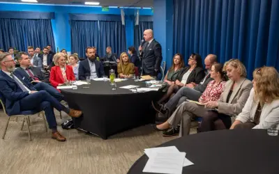 Grupa prawników siedzi przy okrągłych stołach podczas konferencji w Krakowie.
