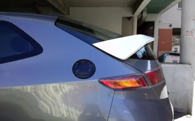 Szary samochód Honda Civic VII z białym spoilerem na klapie bagażnika.