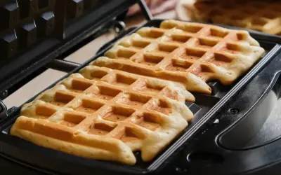Chrupiące gofry w trakcie pieczenia w gofrownicy. Idealne na śniadanie, zgodnie z naszym przepisem na chrupiące gofry.