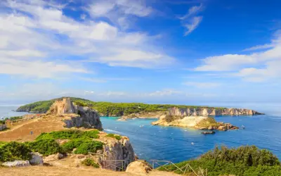 Un antico castello domina le isole della Puglia, con acque azzurre e vegetazione lussureggiante.