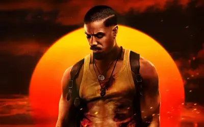 Michael B. Jordan jako John Kelly w filmie "Grzesznicy". W tle wielkie, pomarańczowe słońce.